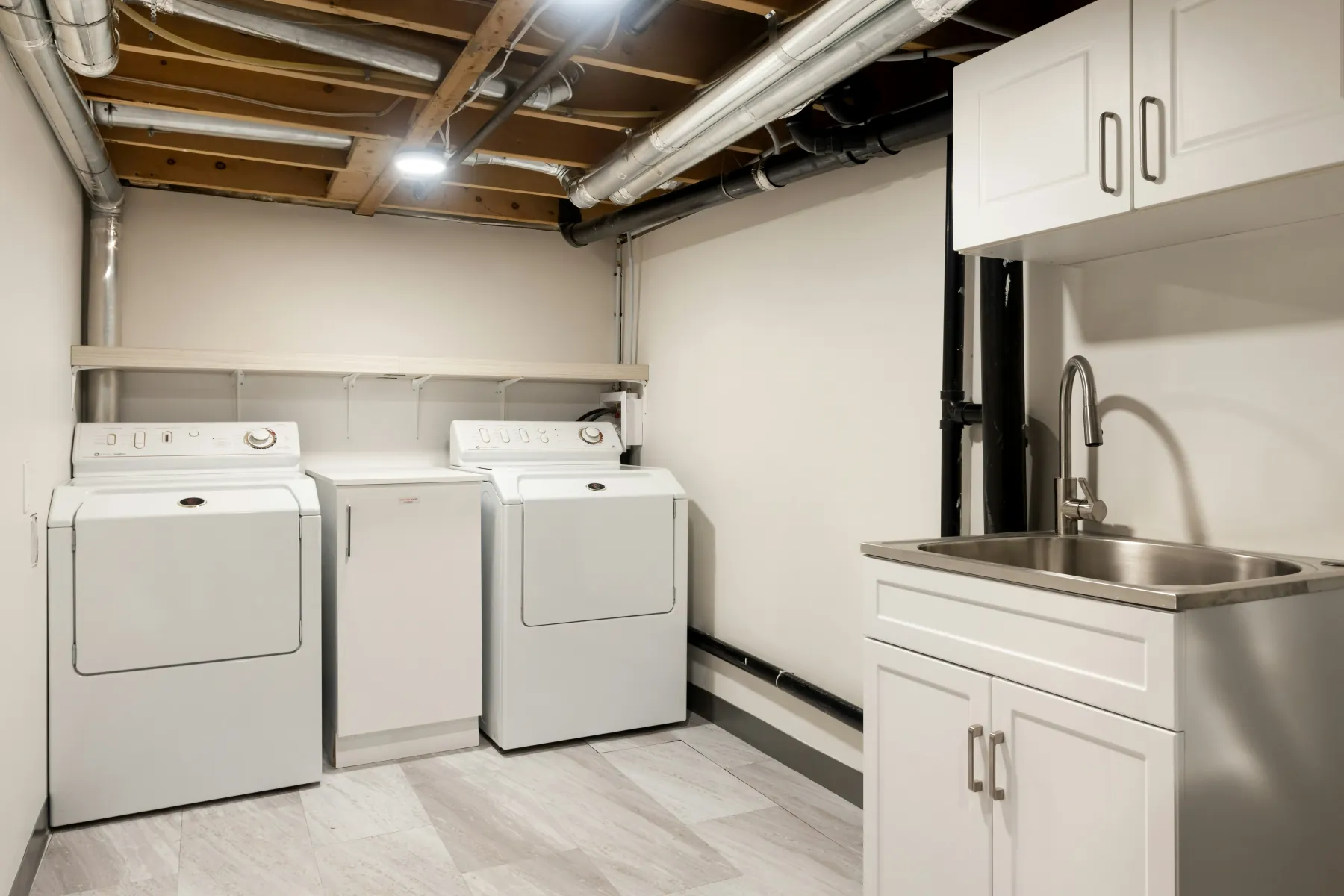 Tidy laundry room with washer, dryer and utility sink